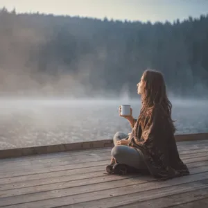 Person som kopplar av vid en sjö under ett retreat i naturen