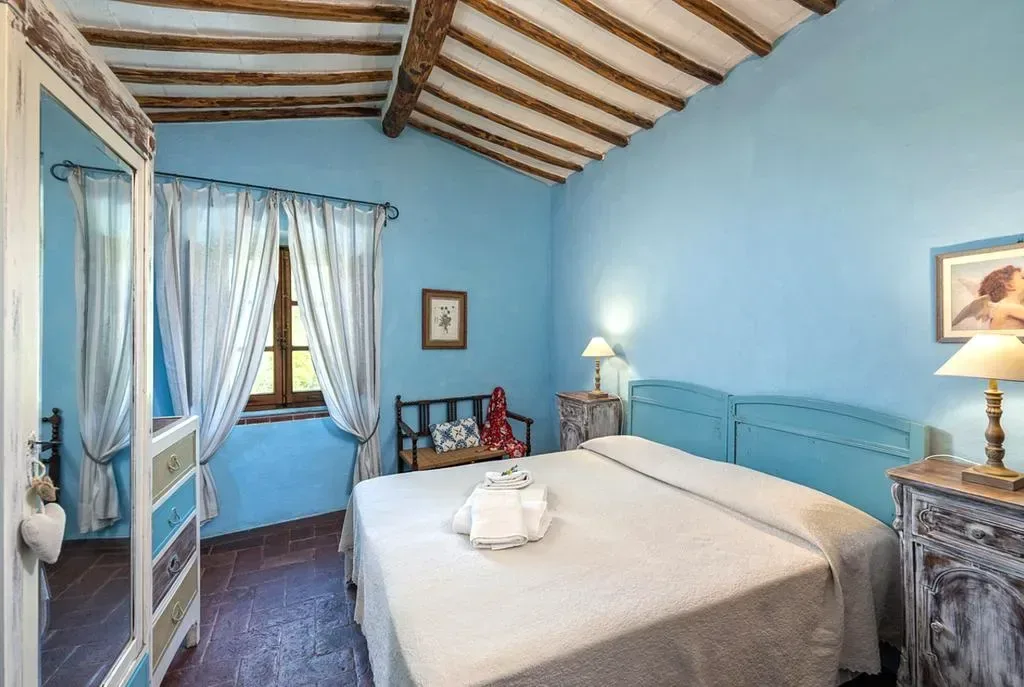 Charmigt sovrum med blå detaljer och autentisk atmosfär på retreatboende i Toscana