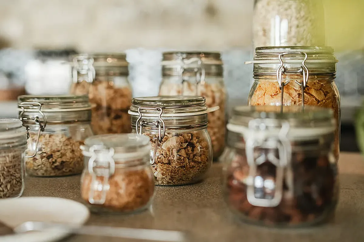 Glasburkar med olika torra ingredienser står på en köksbänk.