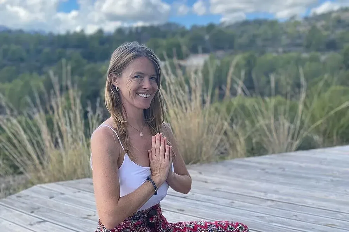 Yogalärare sittande i meditationsposition utomhus på retreat i Spanien