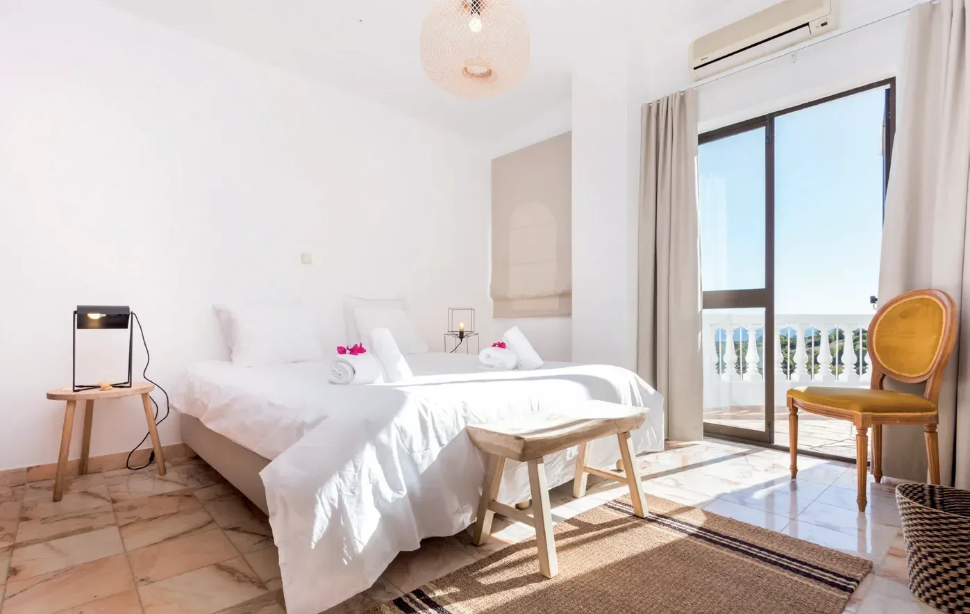 ett vitt sovrum med bekväm säng i boutiquehotellet One life lodge