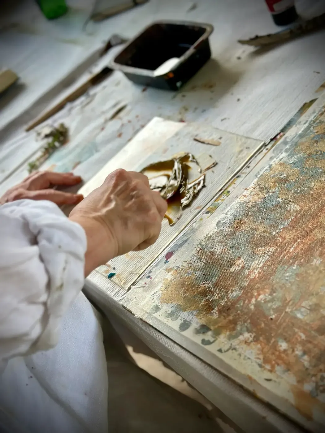 Närbild på konstnär som arbetar med färg under ett kreativt retreat i Toscana