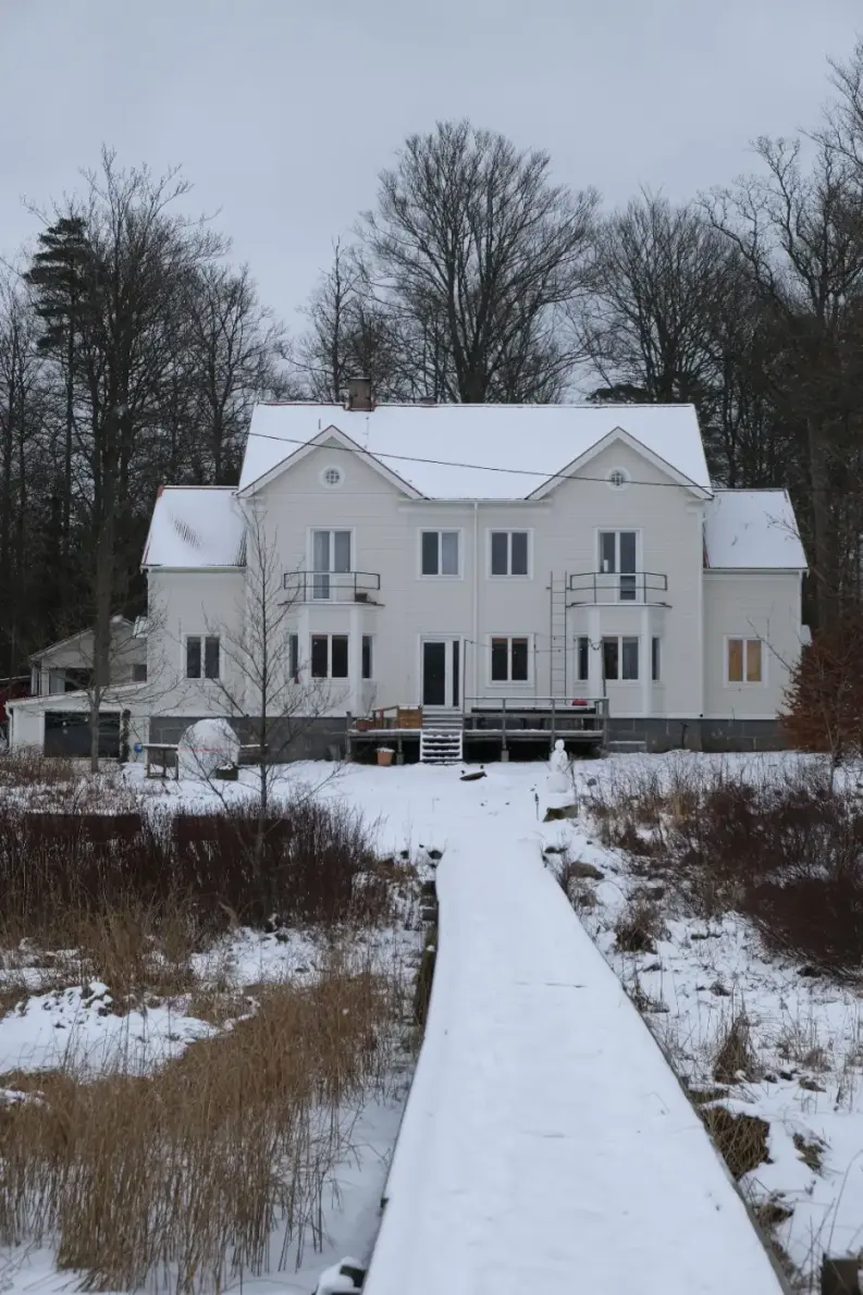 ett vitt vandrarhem i blekinge med brygga ner till vattnet